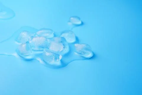 The process of melting ice cubes on a blue Stock Photos