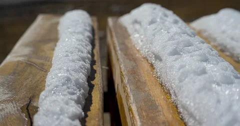 The process of melting snow on a wooden bench Stockbeeldmateriaal 219949585