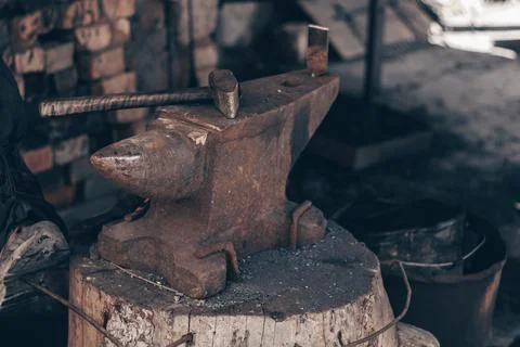 Process metal with hammer on anvil in forge. Strike iron outdoors in workshop Stock Photos