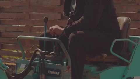 The process of the mini tractor, tractor driver, tractor uproots a tree Stockbeeldmateriaal 334058320