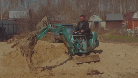 The process of the mini tractor, tractor driver, tractor uproots a tree Vídeo Stock 334058468
