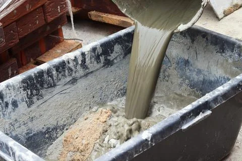 The process of mixing cement at a construction site. Pouring water into a mix Stock Photos