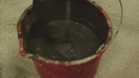 The process of mixing cement mortar in a bucket with a mixer Stock Footage 149295109