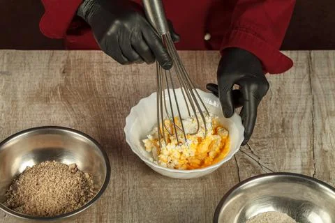 The process of mixing cottage cheese with egg yolk with a metal wedge for 스톡 사진