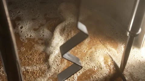 The process of mixing ingredients in a brewing vat. Stock Footage 237312396