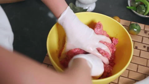 Process of mixing minced meat in bowl, person in gloves mixing seasoned mince Stock Footage 229945468