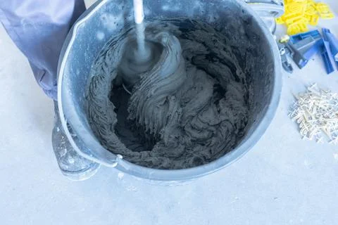 The process of mixing mortar with a perforator with a special nozzle Stock Photos