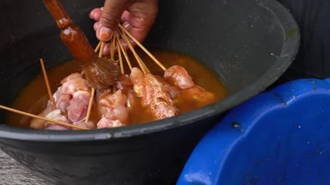 The process of mixing the spices on the chicken sticks to make satay 库存影片 243573479
