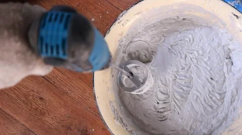 The process of mixing thick mortar with a special attachment Stock Photos