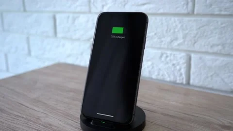 Process of mobile phone charging on an induction station pad. 4k stock footage. Vídeos de archivo 156420451