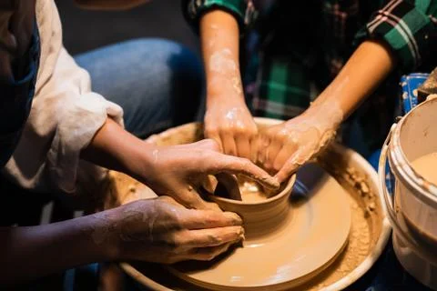 The process of modeling clay dishes on a potter's wheel, the hands of a young Stock Photos