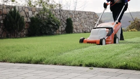 The process of mowing the lawn with lawn mower in autumn calm weather Stock Footage 164873577