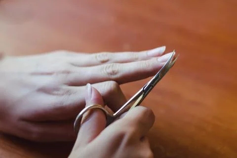 The process of nail clippingl scissors. Hand care concept. Soft focus. Stock Photos