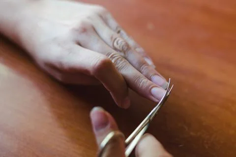 The process of nail clippingl scissors. Hand care concept. Soft focus. Stock Photos