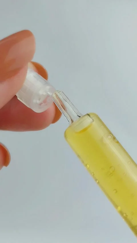 Process of opening the cap of a golden yellow beauty serum. Close up view, .. Stock Footage 331231509