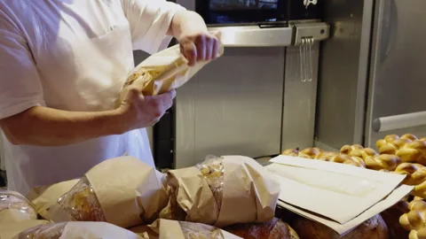The process of packaging dough products in a bakery. The baker packs the bread Stock Footage 277618629