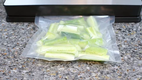 Process of packing cucumbers in bag using vacuum machine on a gray background. Stock Footage 285021224