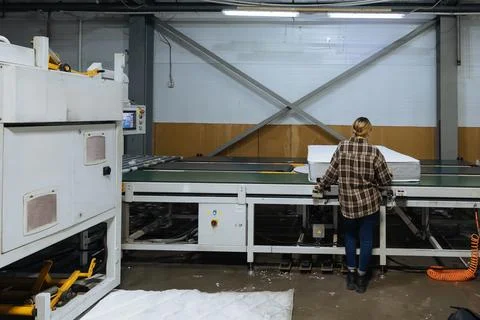Process of packing of mattress. Worker operates mattress packing machine 写真素材
