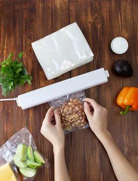 The process of packing nuts in a vacuum bag and sealing with a vacuum cleaner Stock Photos