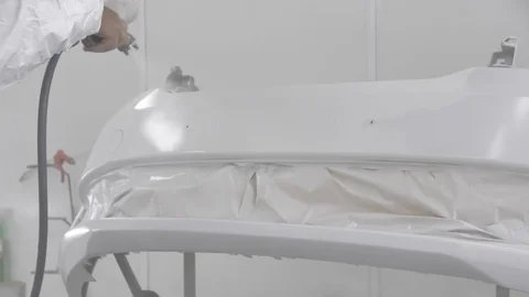 The process of painting the bumper of a white car in a spray booth. Man using a Vídeo Stock 125884573