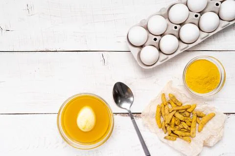 The process of painting Easter eggs with natural plant dyes, turmeric, on a w Foto stock