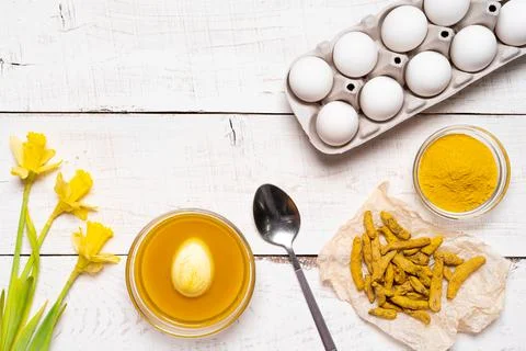 The process of painting Easter eggs with natural plant dyes, turmeric, on a Stock Photos