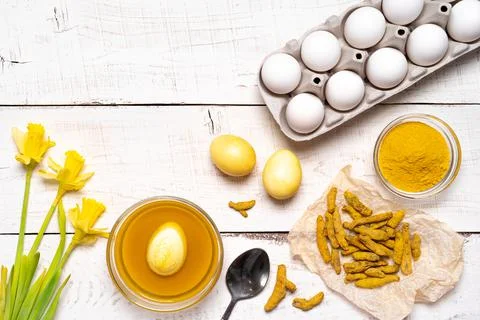 The process of painting Easter eggs with natural plant dyes, turmeric, on a Foto stock