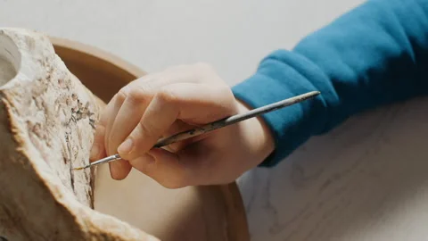 The process of painting a stone in an art studio. Media. Close-up of an artist's Stock Footage 230224203