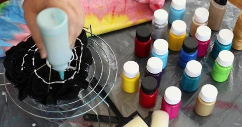 The process of painting in the style of tie dye to t-shirt 3 Stock Footage 135349535