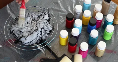 The process of painting in the style of tie dye to t-shirt Stock Footage 135358798