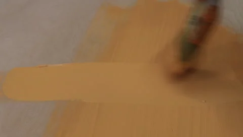 The process of painting the surface with orange paint with a brush Video stock 282904863