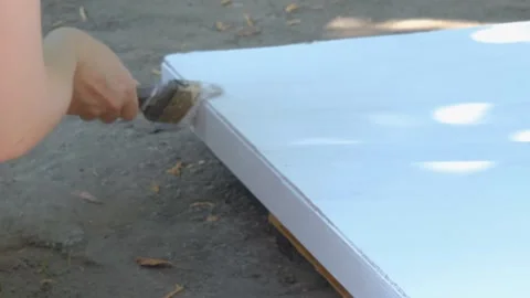 The process of painting with white paint. The brush paints the wooden part white Stock Footage 263149319