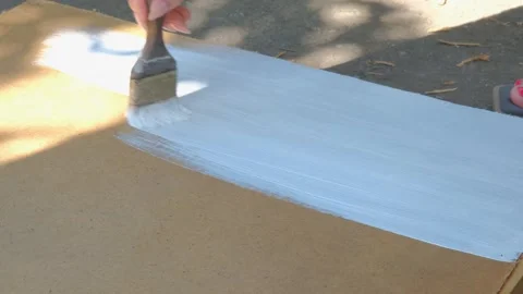 The process of painting with white paint. The brush paints the wooden part white Stock Footage 264062194