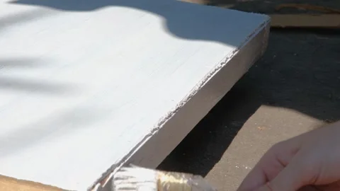 The process of painting with white paint. The brush paints the wooden part white Stock Footage 264541098