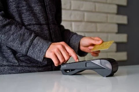 The process of payment for goods through the Terminal. Plastic card. Enter th Stock Photos