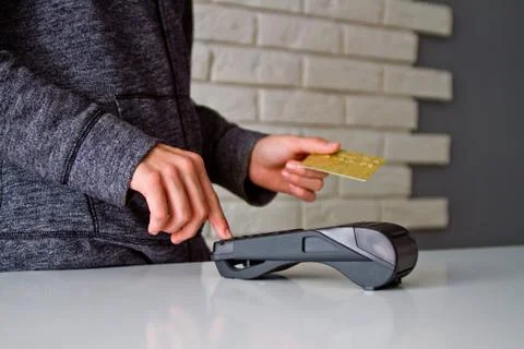 The process of payment for goods through the Terminal. Plastic card. Enter th Stock Photos