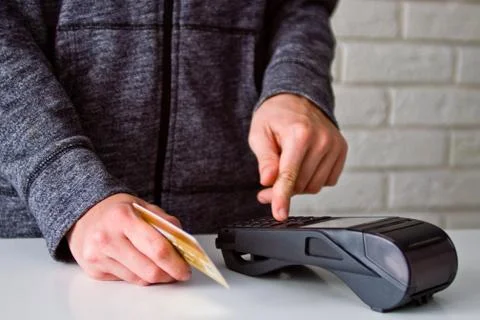 The process of payment for goods through the Terminal. Plastic card. Enter th Stock Photos