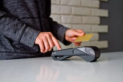 The process of payment for goods through the Terminal. Plastic card. Enter th Stock Photos
