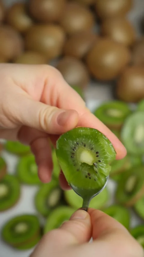 The process of peeling a fresh ripe kiwi fruit with a spoon. Stock Footage 299903903