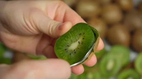 The process of peeling a fresh ripe kiwi fruit with a spoon. Stock Footage 299903952