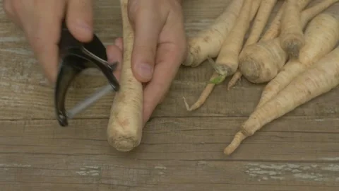 The Process of Peeling Parsnips for Culinary Preparation and Delicious Recipes Stockbeeldmateriaal 283283934