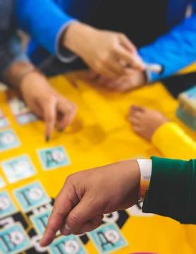 Process of playing board game and having fun with friends and family in roo.. Stock Photos