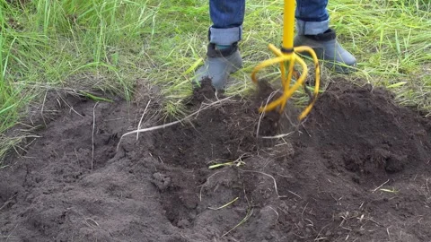Process of plowing agricultural land using hand cultivator tool with pitchfork Stock Footage 248855400
