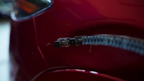 Process of pointless dent repair on car, mechanic at the auto shop with tools to Stock Footage 311612879