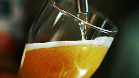 Process of pouring beer into glass beaker in grill bar. Stock Footage