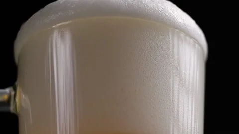 The process of pouring beer into a glass. Beer foam pours over the rim. Stock Footage 169722854