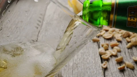 The process of pouring beer from a glass bottle into a beer glass. Snacks in Stock Footage 154217059