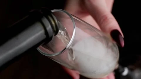 The process of pouring champagne into a glass held by a girl. Stock Footage 170318487