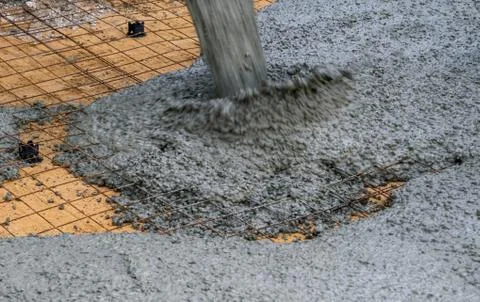 The process of pouring concrete on a prepared base made of sand Stock Photos
