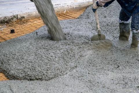 The process of pouring concrete on a prepared base made of sand Stock Photos